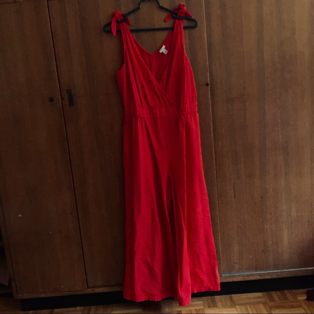 Red waffle textured jumpsuit with adjustable tie straps.